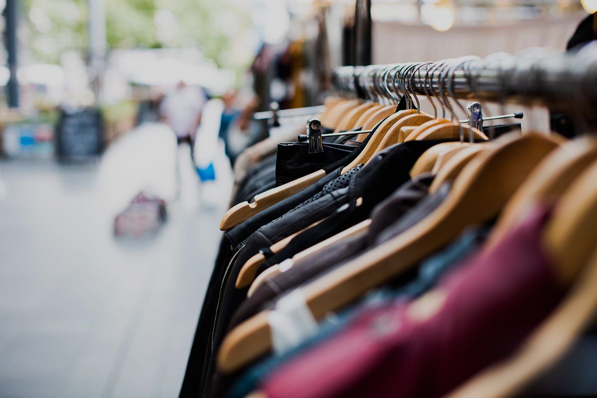 A close-up of stylish clothing on wooden hangers at a local boutique, highlighting the diverse shopping opportunities available to guests staying with Alabama Beach Vacation Rentals.
